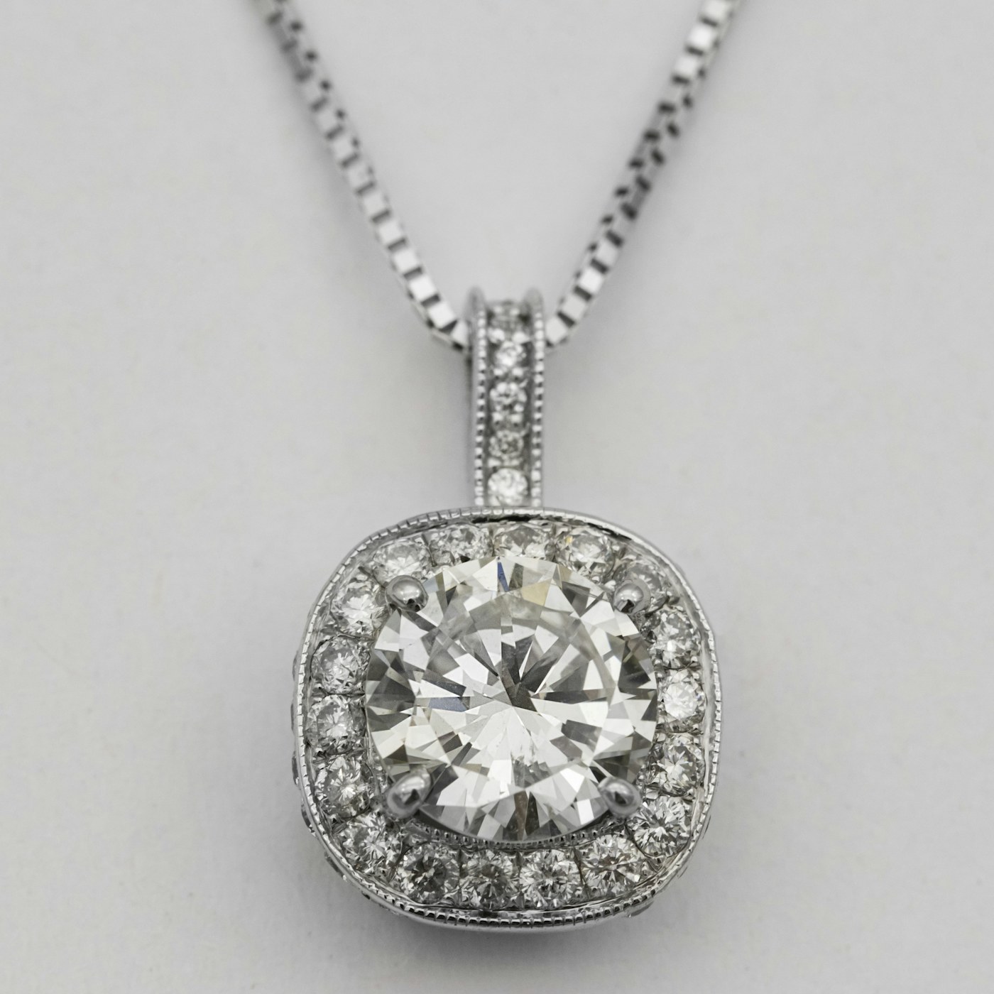 Colgante de oro blanco con diamante central y halo